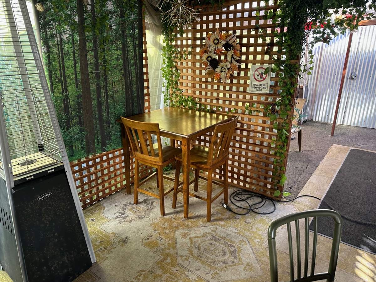 A small wooden table and chairs in the Mercato garden corner