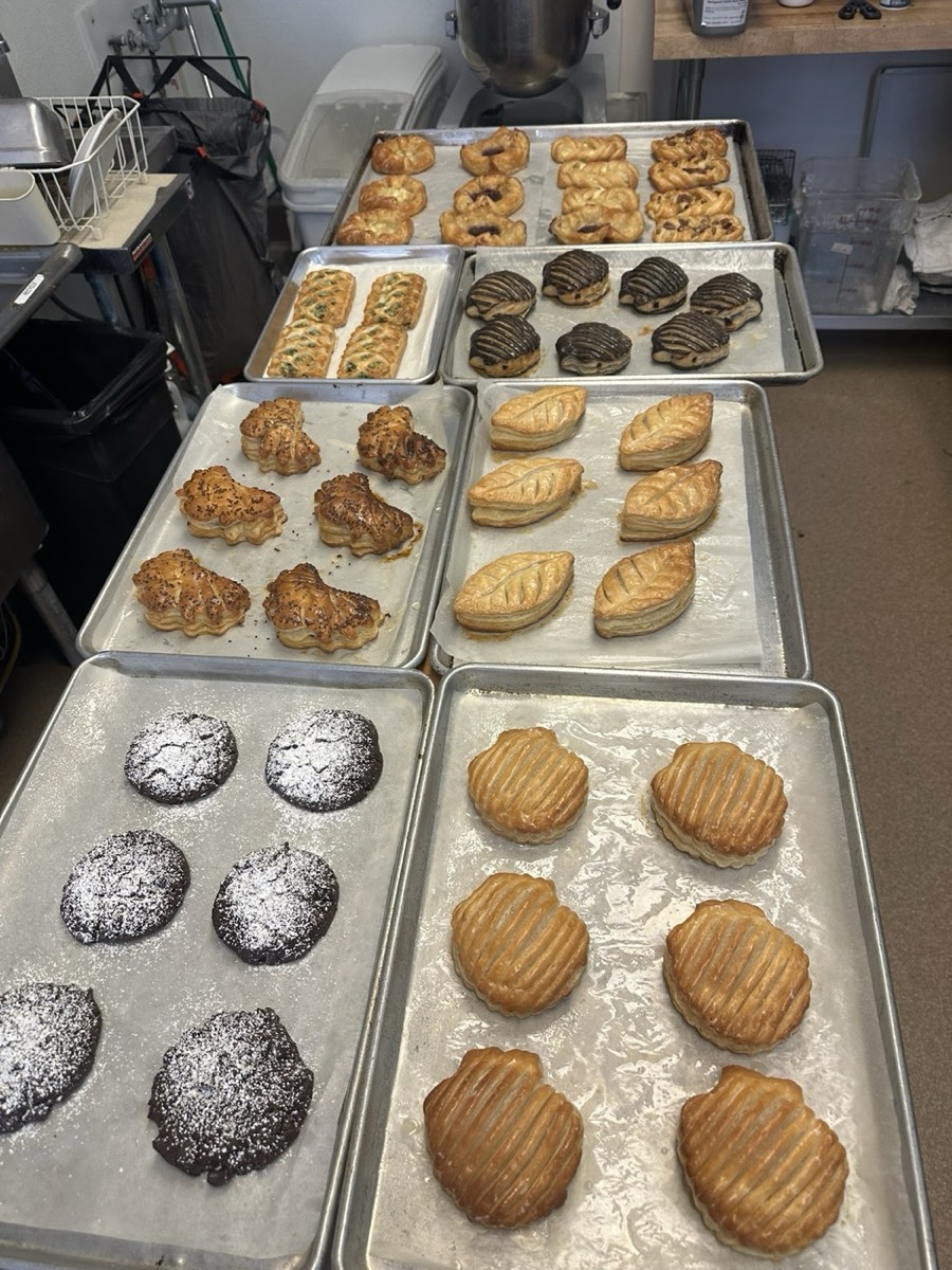 Trays of fresh pastries: shell-shaped puff pastries, powdered-sugar cookies and leaf pastries